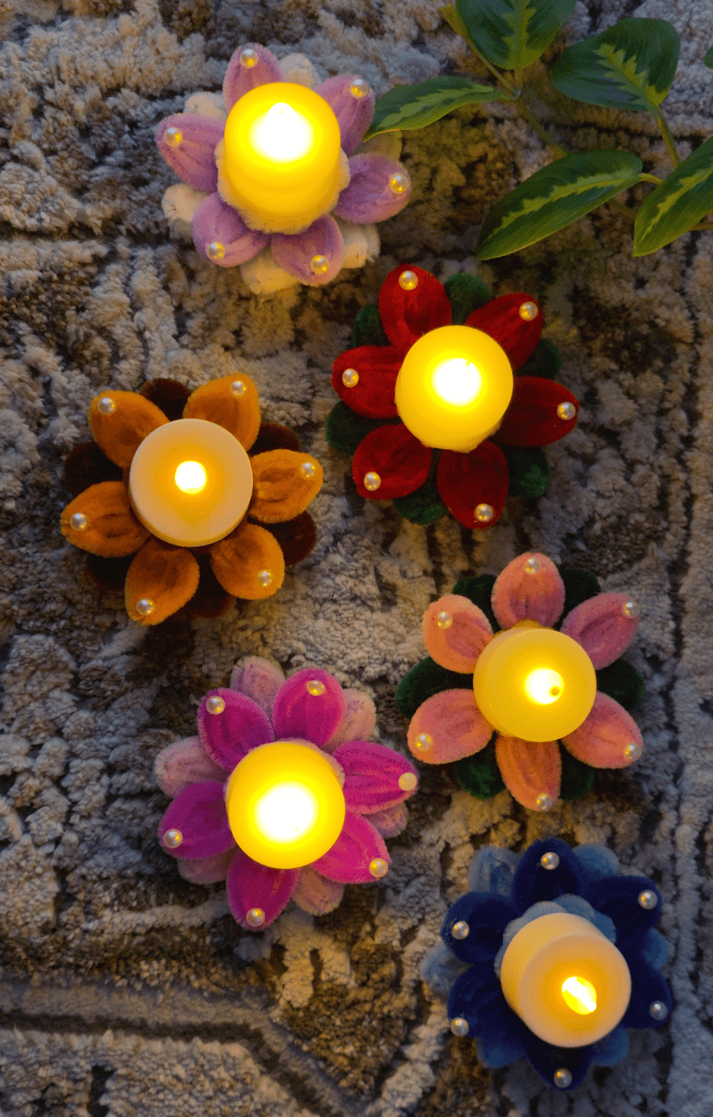 Festive Bloom LED Holder — A colorful handmade floral diya holder featuring soft pipe-cleaner petals, pearl-style accents, and a warm LED tealight center. Perfect for Diwali, festive tables, pooja decor, rangoli arrangements, and gifting.